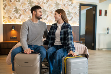 Couple sitting on the bed in a hotel room after arrival
