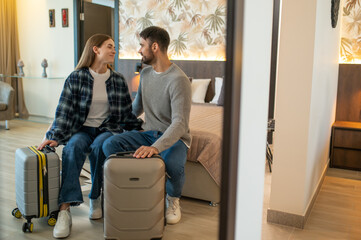 Couple sitting on the bed in a hotel room after arrival