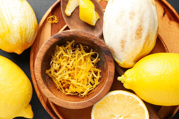 Fresh lemons with zest on black table, flat lay