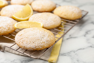 Tasty lemon cookies and fruit slices on white marble table, closeup