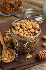 Tasty granola with dried fruits on wooden table, closeup