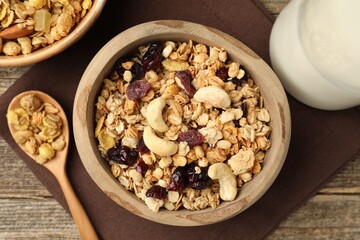 Tasty granola with dried fruits, nuts and milk on wooden table, flat lay