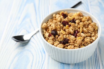 Tasty granola with dried fruits in light blue wooden table, closeup