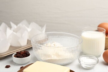 Ingredients for making muffins and cupcake tray on white table, closeup