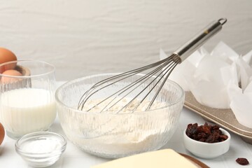 Ingredients for making muffins and cupcake tray on white table, closeup