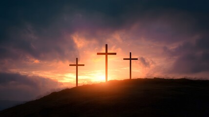 Three silhouettes of religious symbols stand atop a hill against a dramatic sunset sky