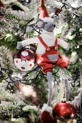 A Christmas mouse sits on a Christmas tree branch, Christmas decorations