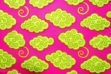 Vibrant pink background with whimsical green cartoon clouds and swirls
