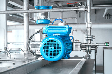 Industrial equipment. New blue electric motors with pumps on the stainless steel production line. Industrial background. Additive pump station in petrochemical technology.