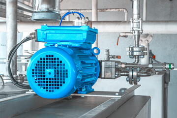Industrial equipment. New blue electric motors with pumps on the stainless steel production line. Industrial background. Additive pump station in petrochemical technology.