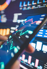 Analyzing stock market trends on a smartphone with charts and graphs