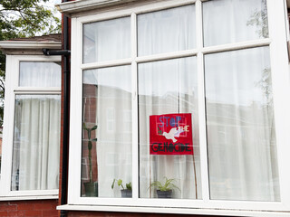 Window protest poster in a Manchester home window demanding stop genocide