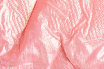 Shiny wrinkled pink textile fabric background. High quality photo