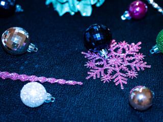Christmas decorations including multi colored ornaments and a pink snowflake. 