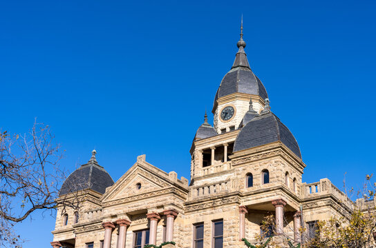 Ornate stone courthouse building in the central downtown square of Denton in Texas