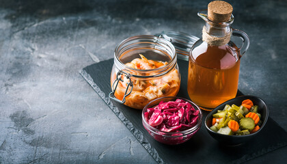 Assortment of healthy fermented foods and beverages on a dark background, promoting wellness