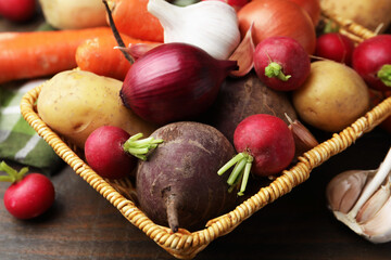 Different raw vegetables on wooden table, closeup