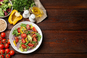 Delicious lentil salad and ingredients on wooden table, flat lay. Space for text