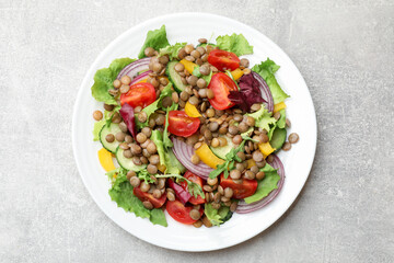 Tasty salad with lentils and vegetables on grey table, top view