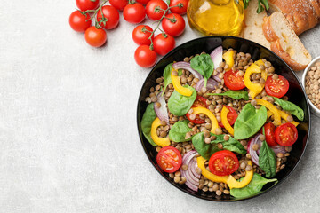 Tasty salad with lentils and vegetables served on grey table, flat lay. Space for text