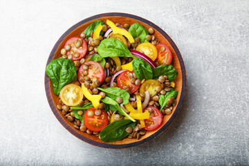 Tasty salad with lentils and vegetables on grey table, top view