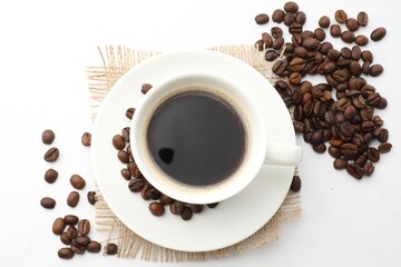 Cup of aromatic coffee and roasted beans on white background, flat lay
