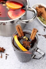 Traditional mulled wine on light grey table, closeup