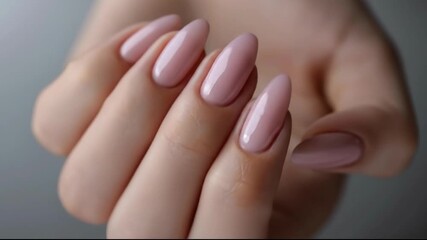 Close-up of elegant glossy pink almond shaped manicured nails.