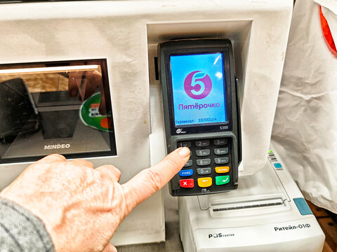 Kirov, Russia - September 05, 2025: Customer making payment at a checkout counter in a grocery store during midday shopping hours