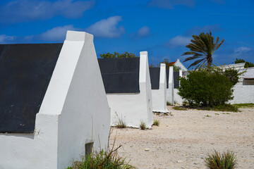 Historic white Slave Huts (Slave Houses) on the Salt Flats Coast of Bonaire in the Dutch Caribbean