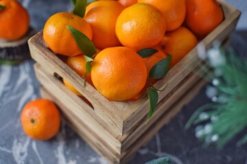 Obraz premium Juicy tangerines or clementines in a wooden box