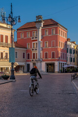 Obraz premium A cyclist passes through Piazza Vittorio Emanuele II, Rovigo, Italy