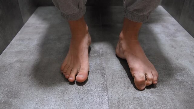 Close-up view of a man's bare feet doing exercises to strengthen the ankles, arches, and toes, performing rotations and flexing for joint mobility, rehabilitation, and physical therapy