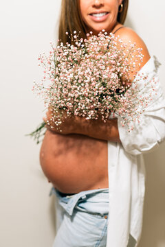 Pregnant woman holding flowers in serene moment