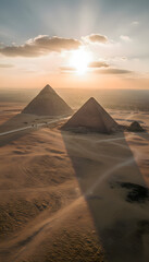 Wide aerial view of the Giza pyramids at sunrise, captured from a high drone perspective