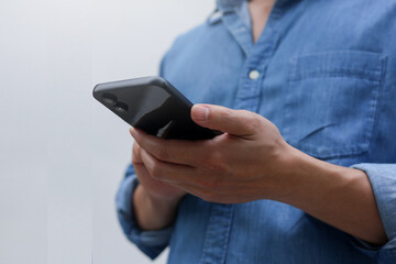 close up businessman hand hold smartphone to surfing the internet and check work or mail on website while sit in the living room in weekend for business technology and lifestyle concept