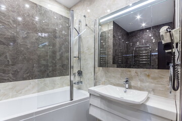 The bathroom shows a layout with a shower and tub combination. A sink with a mirror is present. The...