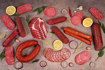 Delicious, aromatic appetizers of various salami cuts for the holidays. A selection of various smoked and dry-cured sausages and spices on a kitchen background. Advertising and menu for a store