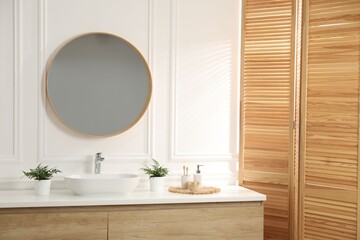 Fototapeta premium Bathroom with stylish mirror, vessel sink and houseplants. Interior design