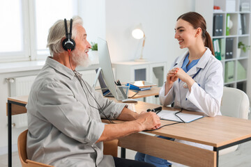 Patient with audiometric headphones undergoing hearing test in clinic © New Africa
