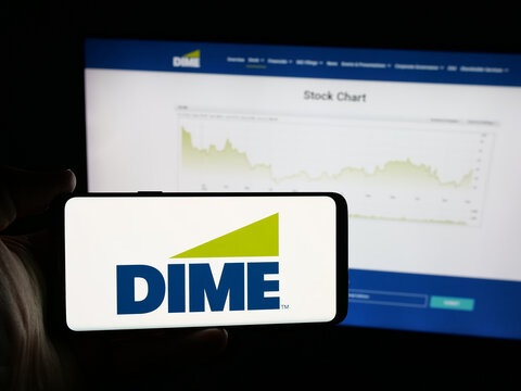 Stuttgart, Germany - 12-05-2025: Person holding smartphone with logo of US financial company Dime Community Bank on screen in front of website. Focus on phone display.