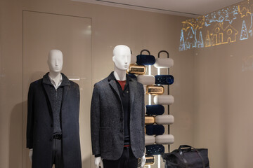 Mannequins displaying men's winter fashion in a boutique window