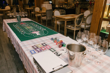 Obraz premium A green field with a stack of chips and cards for playing in a wine casino. Colored chips for gambling.Casino and Entertainment concept.Russia,Moscow,1.01.2022.