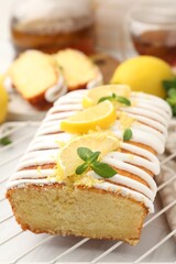 Delicious lemon cake with glaze, fresh fruit slices and mint on table, closeup