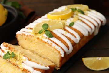 Delicious lemon cake with glaze, fresh fruit slices and mint on table, closeup