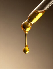 yellow oil pouring out of a pipette, drops of oil	