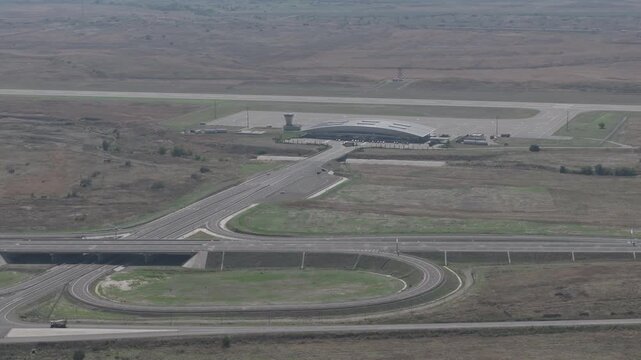 Aerial drone view of Fuzuli International Airport terminal, runway and modern highway junction in Karabakh, Azerbaijan