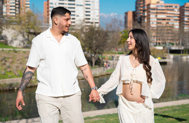 Fototapeta premium Una pareja enamorada camina por un parque de Santiago en el fondo se ve un hermoso lago