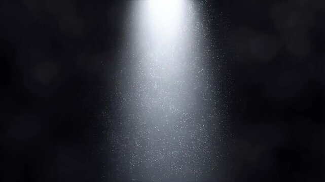 Slow motion white light beam illuminating swirling dust particles with ethereal shimmer in dark background