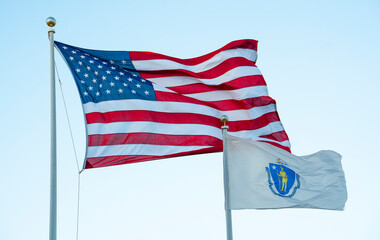 Massachusetts state flag and USA flag waving on the pole in the wind